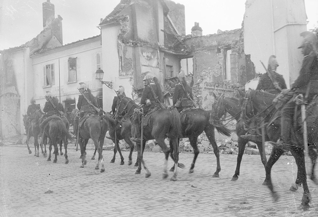 French cavalry pass through the ruined town of Senlis, about 30 miles north of Paris, after it was shelled and occupied by the German Army, September 1914.