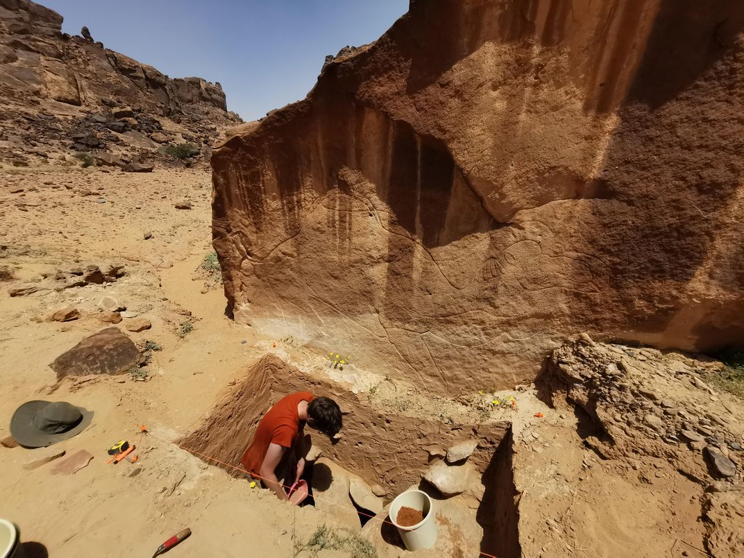 An excavation trench beneath rock art at Jebel Arnaan
