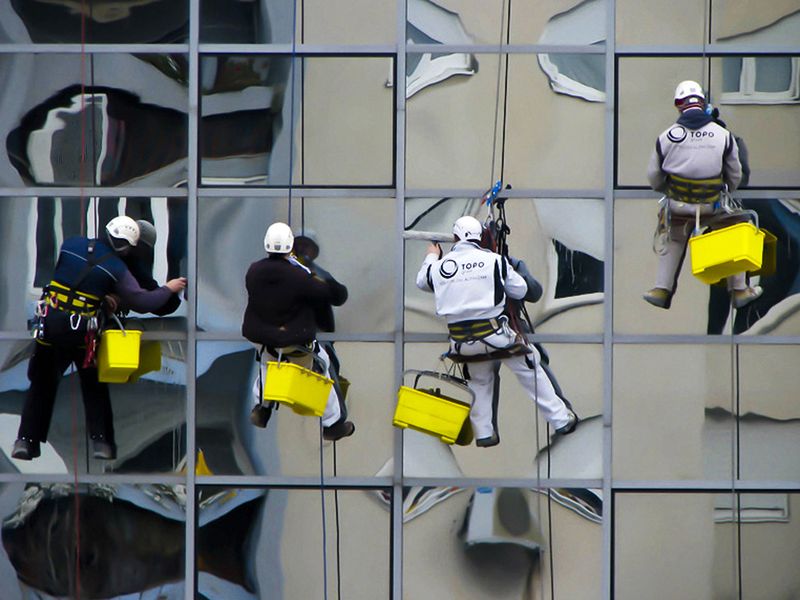 Photo of a window washers washing the windows of a building