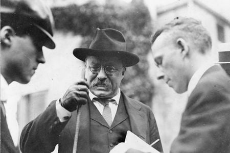 President Theodore Roosevelt clenches his teeth as he makes a point during an interview with unidentified journalists.