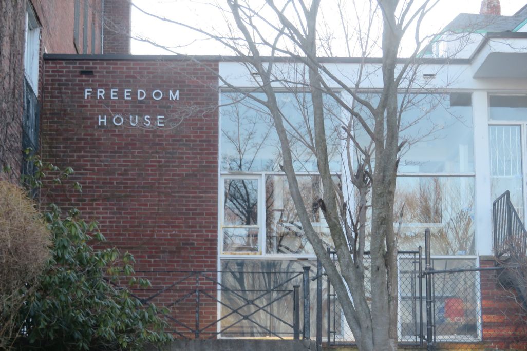 Glass entrance to red brick building Freedom House