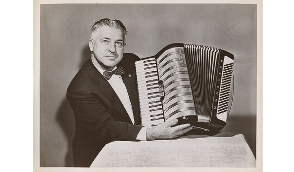 Photograph of John Vassos holding the Marchesa model accordion he designed for M. Hohner, 195-? / unidentified photographer. John Vassos papers, 1915-1989. Archives of American Art, Smithsonian Institution.