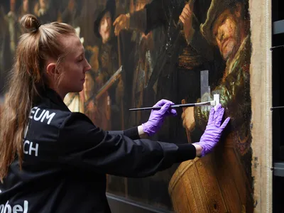 The Public Is Watching as Conservators Carefully Restore a Rembrandt Masterpiece to Its Former Glory image