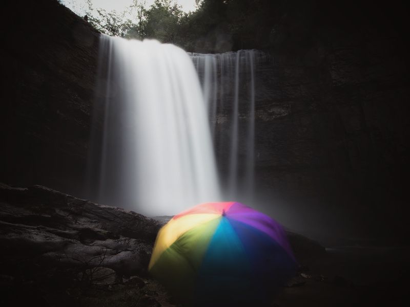 Person with an umbrella watching the waterfall Smithsonian Photo Contest Smithsonian Magazine