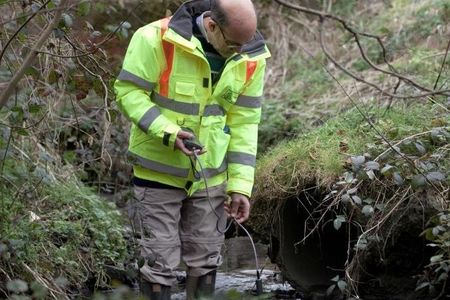 David Lerner uses a conductivity and temperature meter to test for sewage in water, a method that's more costly and less effective than using tampons. 