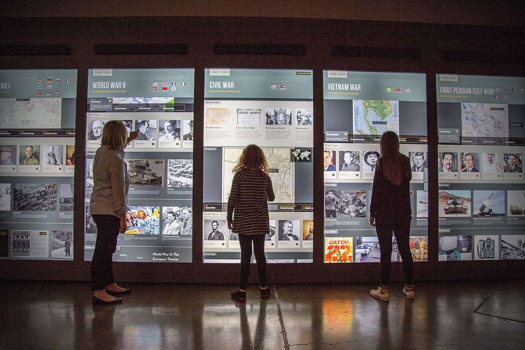 Jumbo touchscreens engage visitors in contemplating the causes of war.