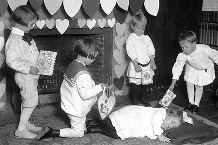 Admirers present valentines to a girl who is pretending to be sleeping, c. 1900s.  In the 18th and 19th centuries, British children celebrated Valentine's Day by going door to door, singing songs.