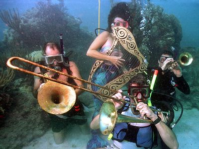 Divers participating in the Underwater Music Festival pretend to play musical instruments in the waters off of Big Pine Key, Florida.