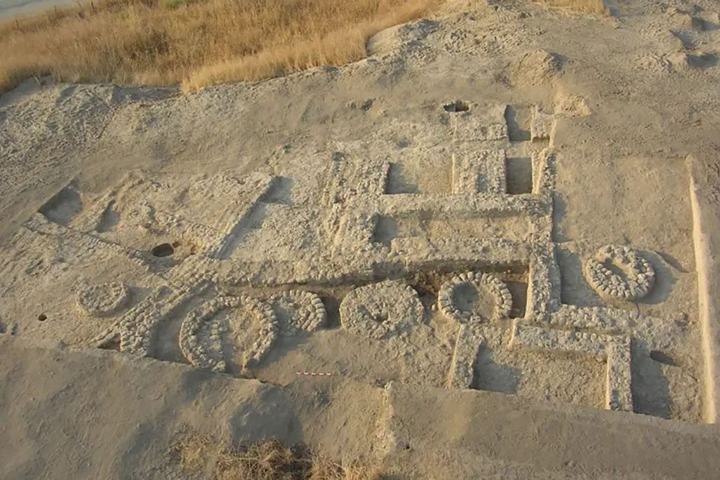 overview picture of slightly unearthed structures in sand that formed prehistoric silos
