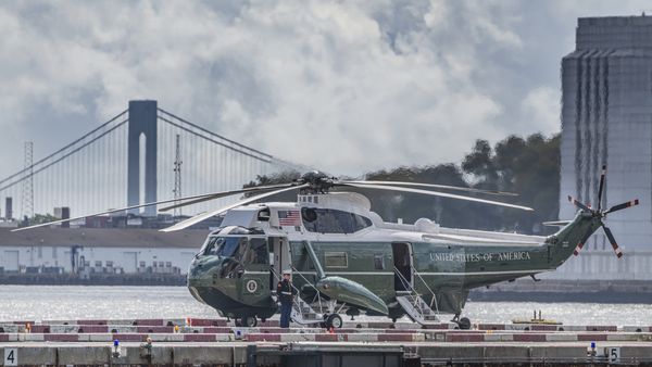 US Marine Stands Sentinel In Front Of Marine One Helicopter, Awaiting Arrival of President Biden On The Wall Street Helipad, With NY Harbor and Verrazano Bridge in Background. thumbnail