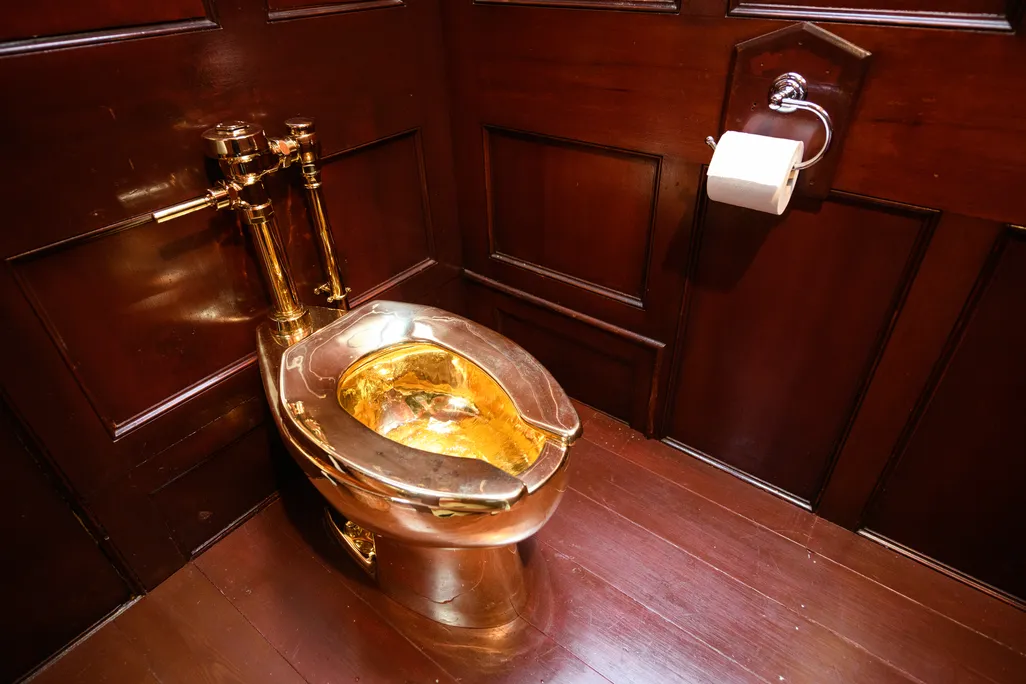 Gold toilet against rich wood paneling