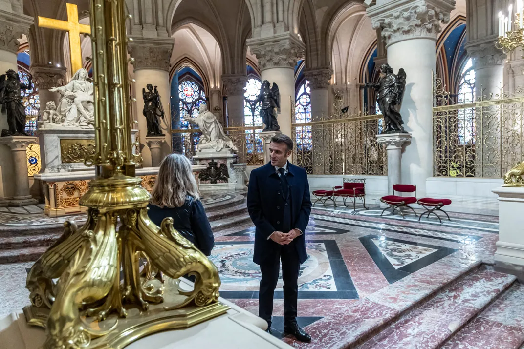 Man wearing black standing in cathedral next to woman with blonde hair