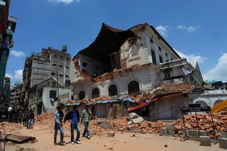 People walk past the damaged Durbar High School a few days after the major earthquake that struck Nepal in April.