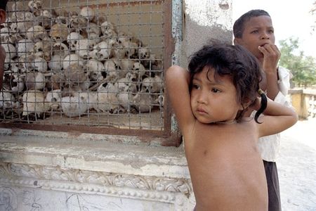 Children stand near a memorial at Cambodia’s killing fields