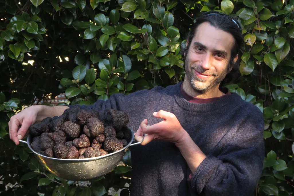 a man holding a bucket of truffles