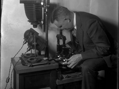 Wilmer Souder poses with a microscope—one of the newfangled tools with which he helped pioneer the field of forensic science.