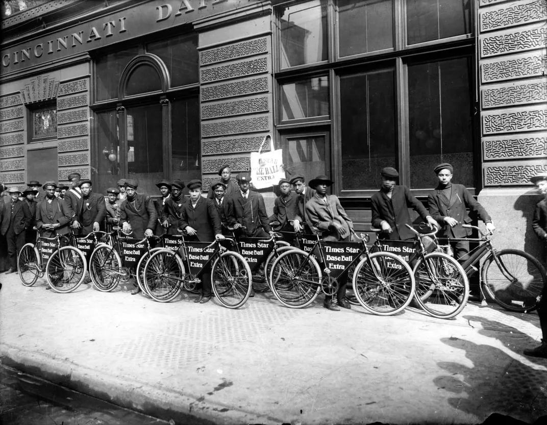 A line of paperboys (and men) pose with their bicycles as they wait outside the offices of the Cincinnati Daily Star to pick up and deliver the Times-Star baseball edition in Cincinnati, Ohio, in the late 19th century.