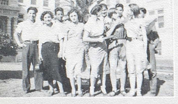 Group of teenagers in front of a school building.