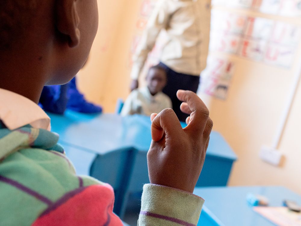 Student using Kenyan Sign Language to recite her alphabet at the