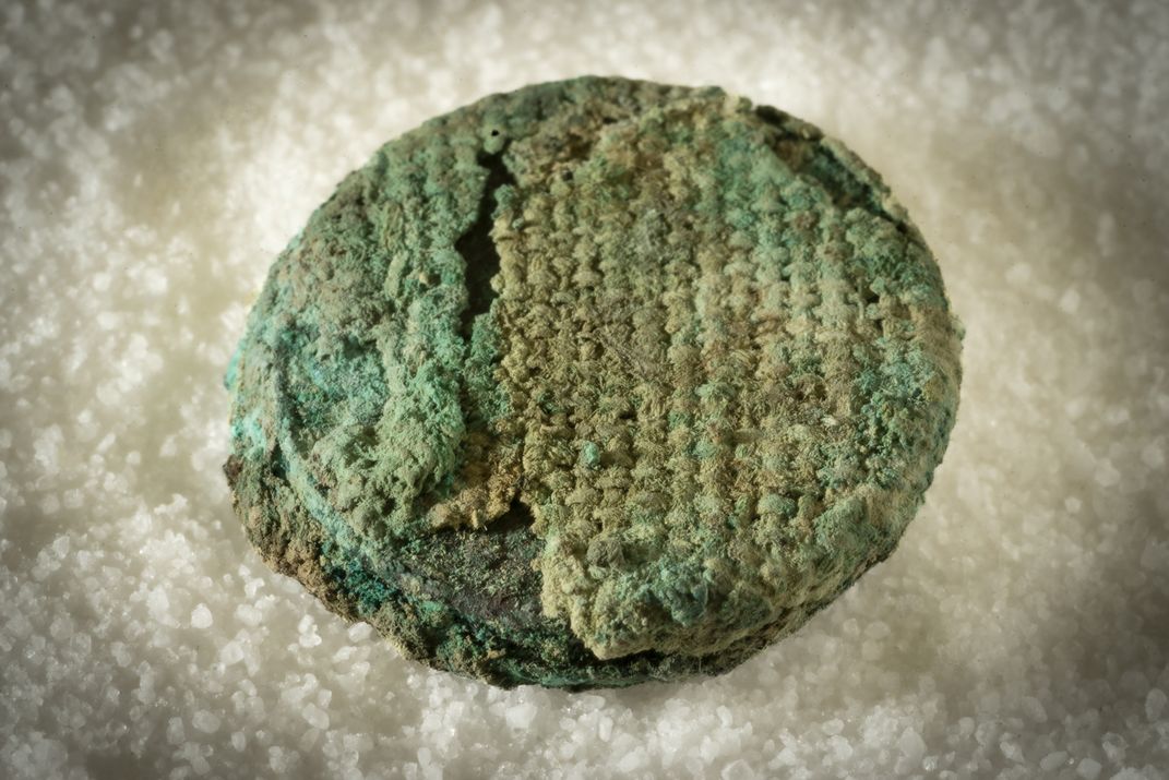 Inside a bark pouch within the grave of a warrior discovered in 2024, archaeologists found three fused bronze coins wrapped in a textile