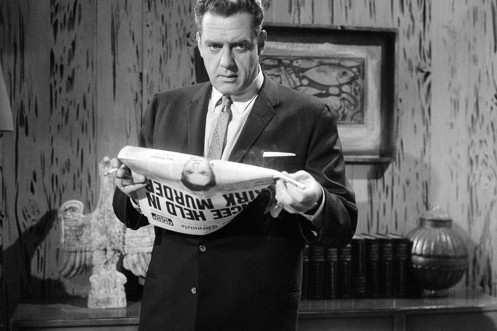 the character Perry Mason holding a newspaper and looking thoughtful