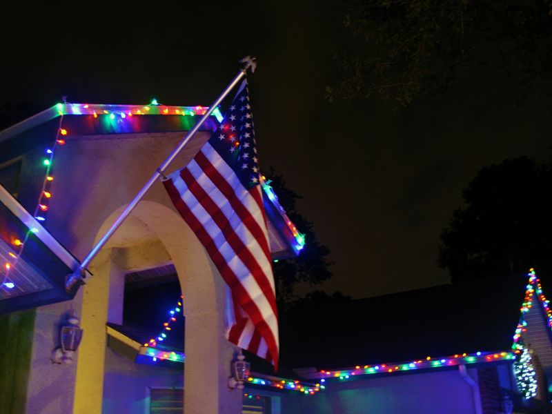 An American flag on a house with Christmas lights Smithsonian Photo