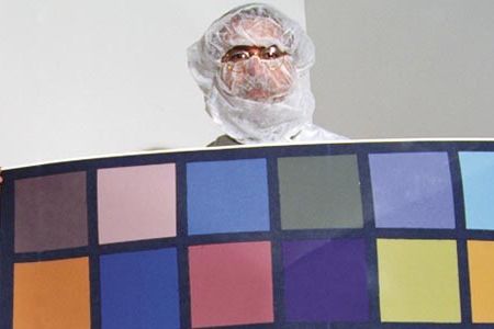 During ground tests in a clean room last July, Mike Malin holds a color chart used to calibrate one of his Mars-bound cameras.