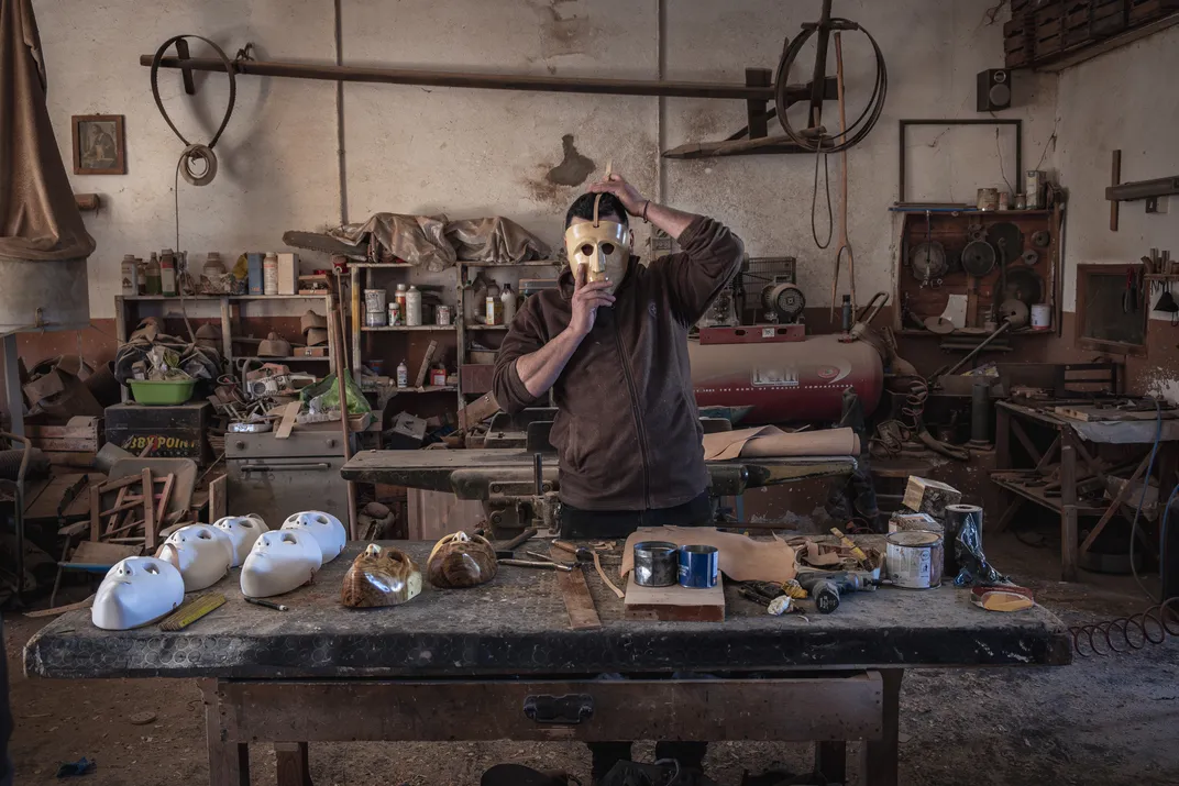 At his workshop in Mamoiada, Daniele Mameli tries on an unfinished Issohadore mask. He and his father, Ruggero Mameli, craft the traditional masks for the festival.