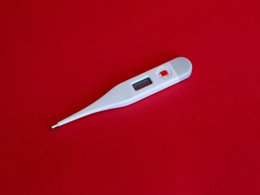 Thermometer on red background