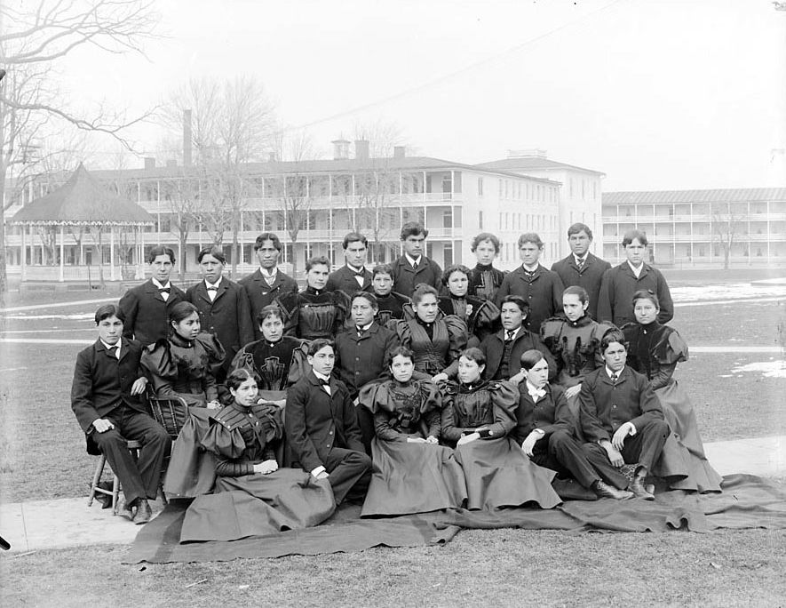 Group_of_Male_and_Female_Students;_Brick_Dormitories_And_Bandstand_in_Background_1879.jpg