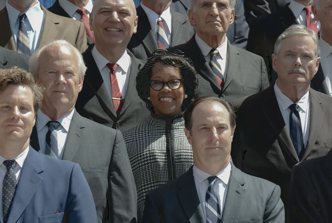 Regina King as Chisholm standing with colleagues