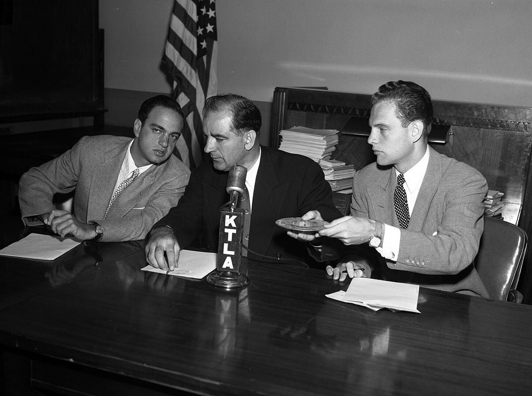 Senator Joseph McCarthy, center, confers with Roy Cohn, chief counsel for the House Un-American Activities Committee, during questioning of William Taylor.