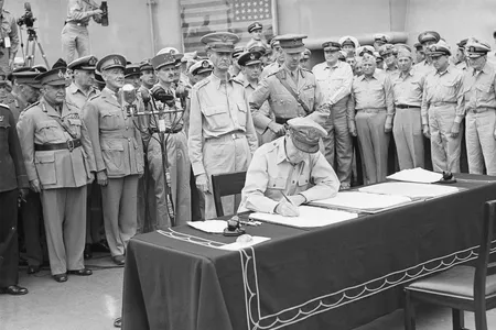 The 31-star Perry flag is visible in the background of this photo, which shows United States General Douglas MacArthur signing the official Japanese surrender on September 2, 1945.