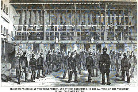 Prisoners walk the treadmill at Coldbath Fields prison in England, circa 1864. Other prisoners are exercising in the yard below.