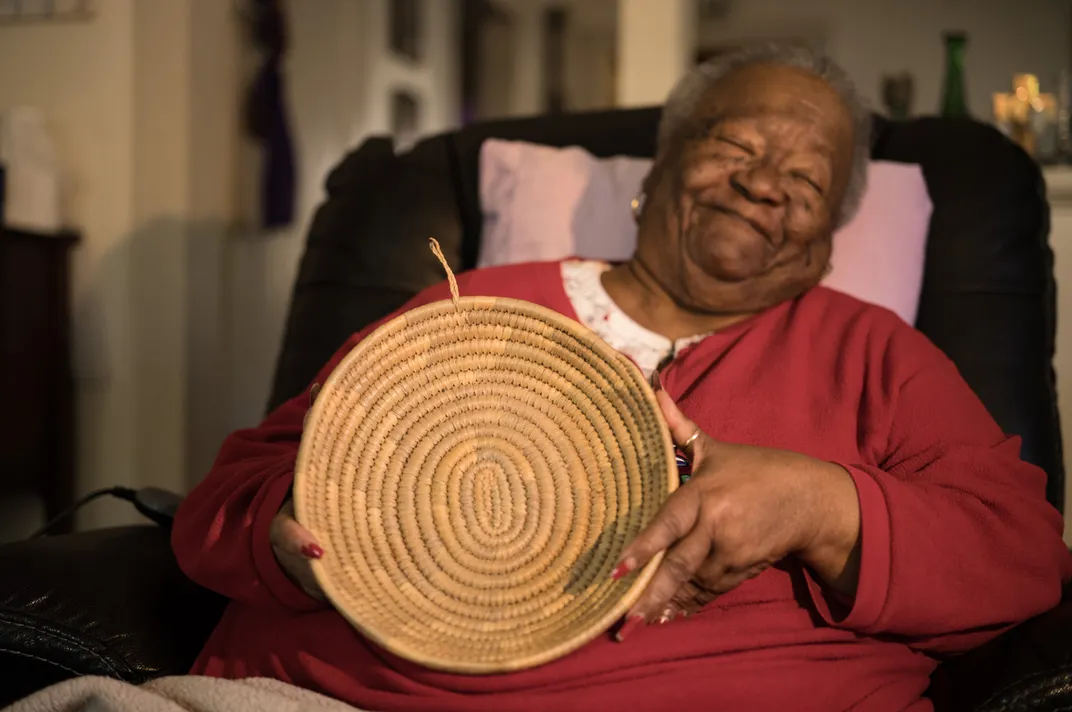 Amy Lotson Mitchell displays a hand-woven basket made from sweetgrass. Africans who survived the Middle Passage brought this skill with them to the Lowcountry and passed it down to their descendants for generations. The tradition is considered part of the