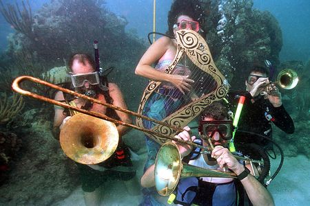 Divers participating in the Underwater Music Festival pretend to play musical instruments in the waters off of Big Pine Key, Florida.