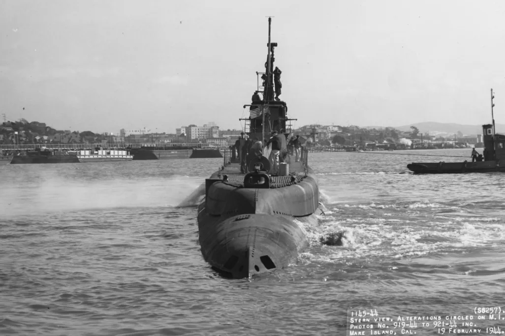 Black and white photograph of surfaced submarine in the water