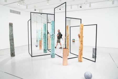 To walk within Alicja Kwade's enigmatic installation, WeltenLinie, where large metal rods frame double-sided mirrors, is like passing into some strange new dimension.