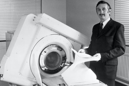 Godfrey Hounsfield stands beside the EMI-Scanner in 1972.