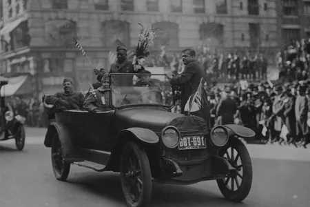 Sergeant Henry Johnson (standing, holding bouquet of flowers) and the Harlem Hellfighters at a 1918 victory parade in New York City