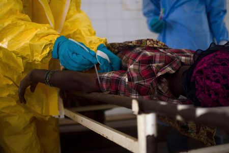 Medical staff take a blood sample from a suspected Ebola patient at the government hospital in Kenema, July 10, 2014