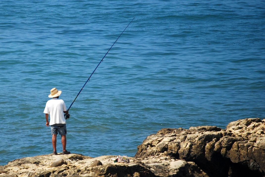 A fisherman fishing off the coast of Morocco. Smithsonian Photo Contest Smithsonian Magazine