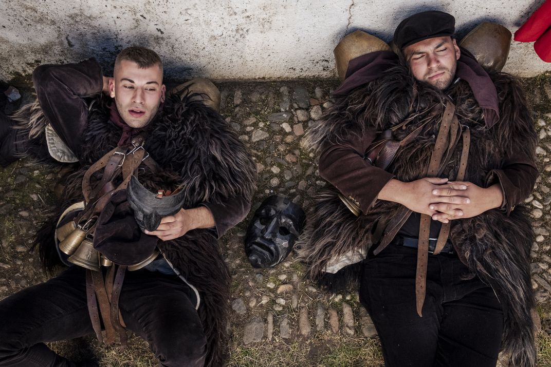Danilo Gungui and Stefano Sini take a moment to relax before the grueling all-night procession, which can go on as long as seven hours.