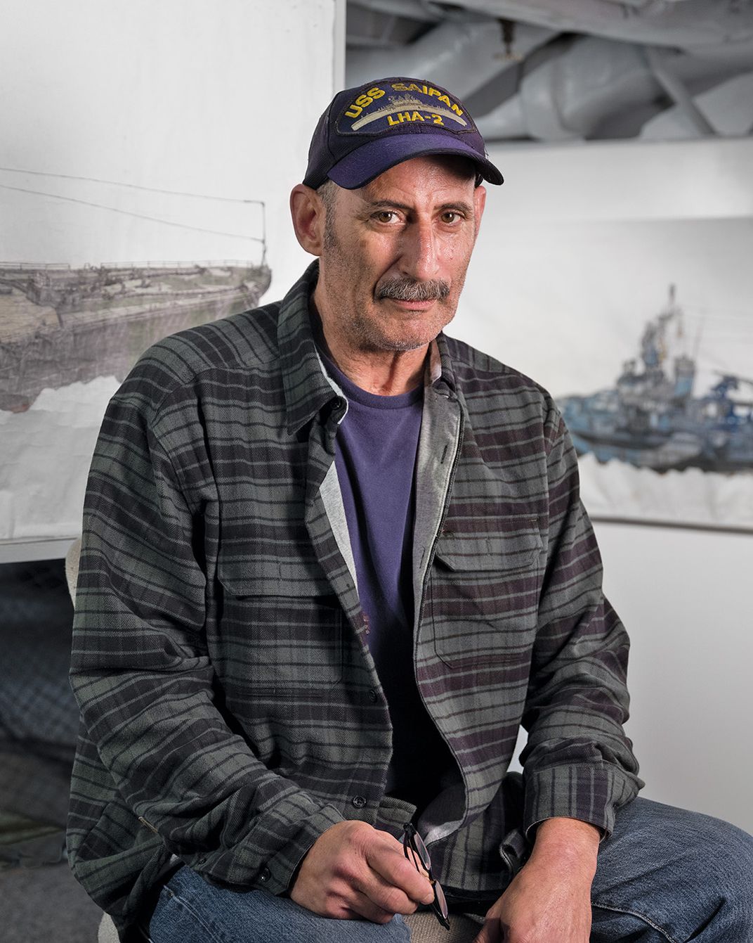 a man wearing a hat sits for a portrait