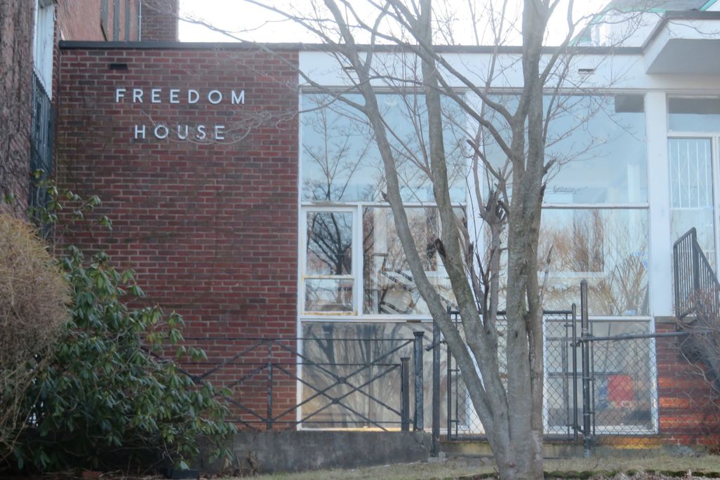 Glass entrance to red brick building Freedom House