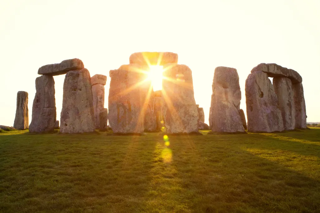 The sun shining through Stonehenge