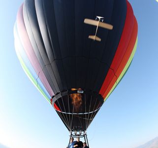 Wide angle view of a hot air balloon, from a camera suspended by the balloon. Note the cord in upper right. This can easily be taken out, as with C3 (26) and (2). This image also has a model airplane looping in front of the camera