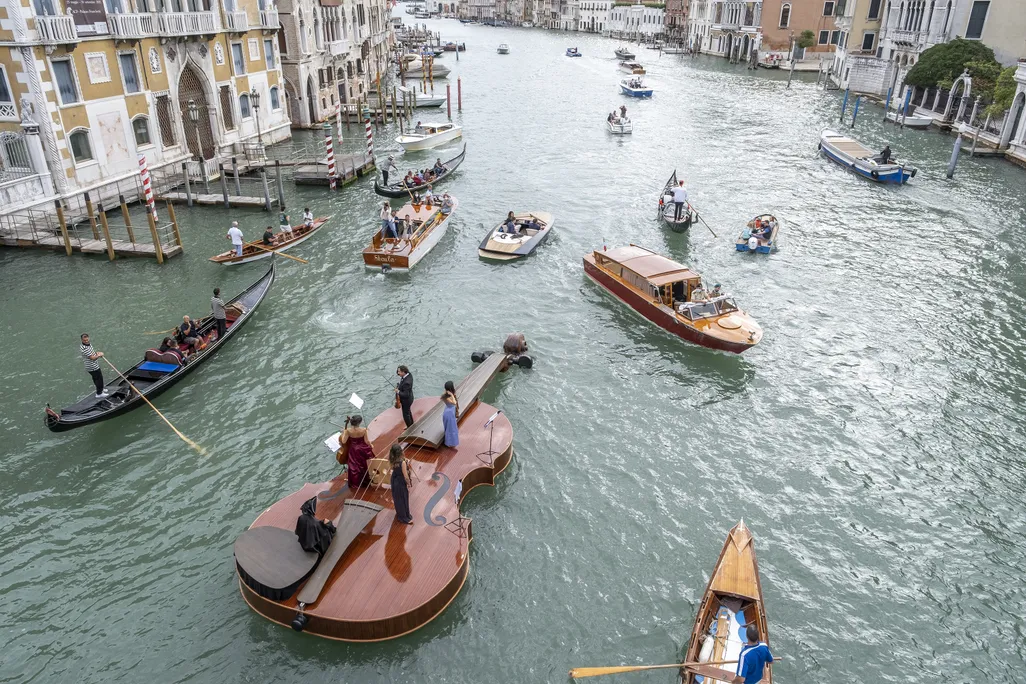 Aerial view of violin vessel sailing down Venice's Grand Canal