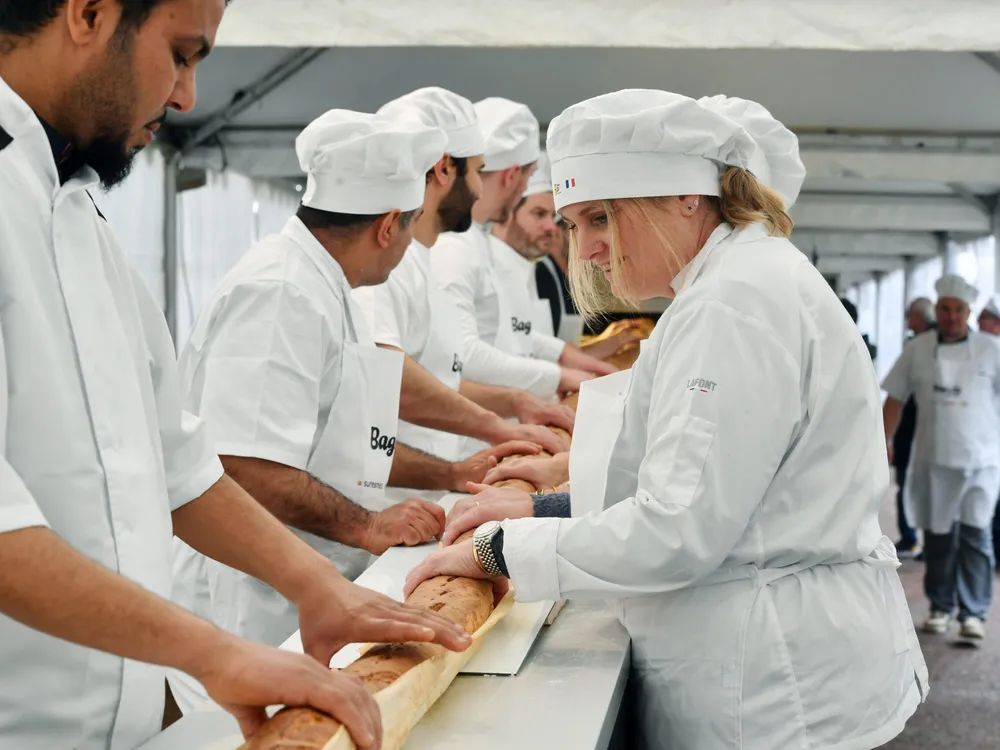 French bakers holding a long baguette