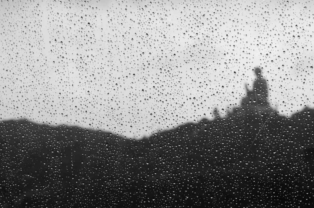 9 - A serene moment unfolds as the Buddha is revealed amid a gentle rain shower.